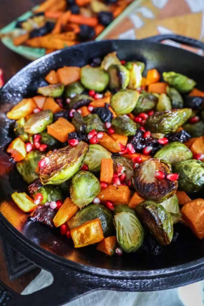roasted sweet potatoes and brusssels sprouts in a cast iron skillet