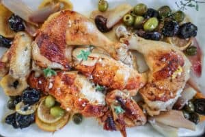 carved roasted chicken garnished with caramelized citrus, olives and prunes