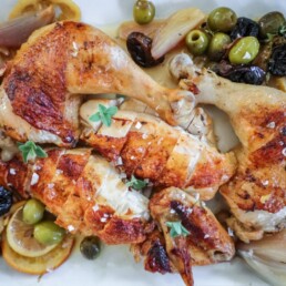 carved roasted chicken garnished with caramelized citrus, olives and prunes