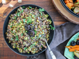 wild rice pilaf in black serving bowl on a table flatlay