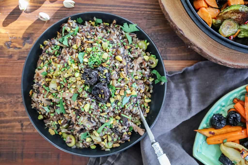wild rice pilaf in black serving bowl on a table flatlay