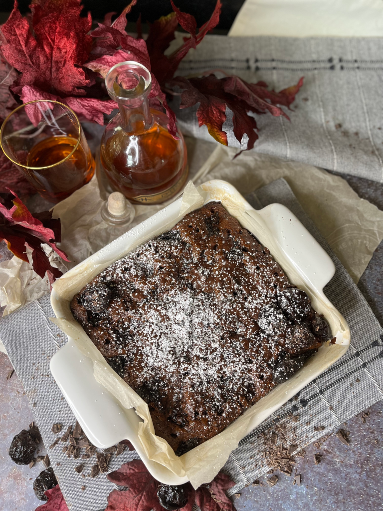 Rachel Dunston's Boozy Chocolate Poke Cake in a pyrex surrounded by poinsettias