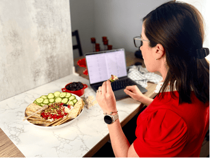 woman sitting at a computer with a whipped feta appetizer