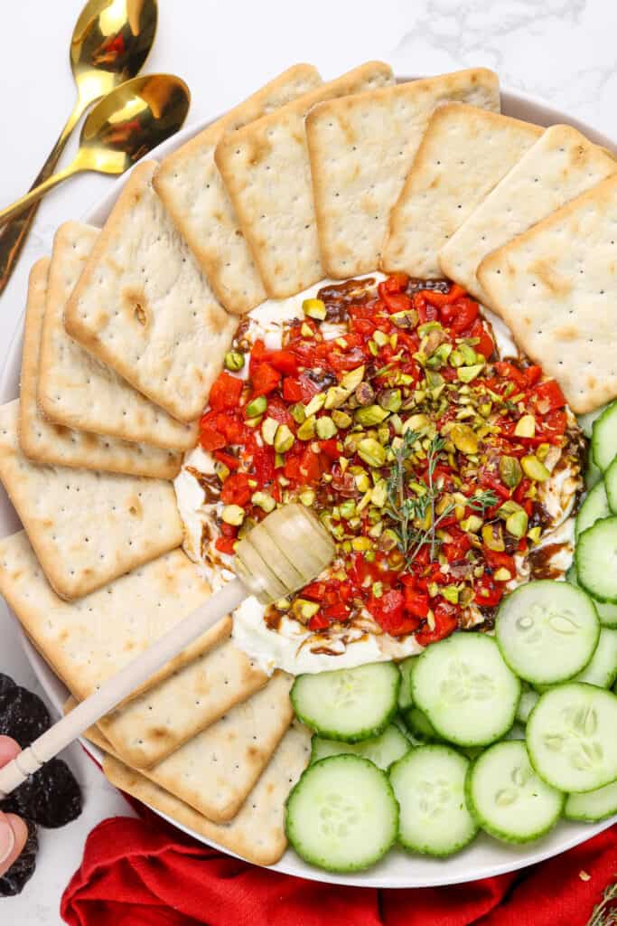 Mediterranean whipped feta dip topped with roasted red bell peppers and garnished with crackers and cucumbers