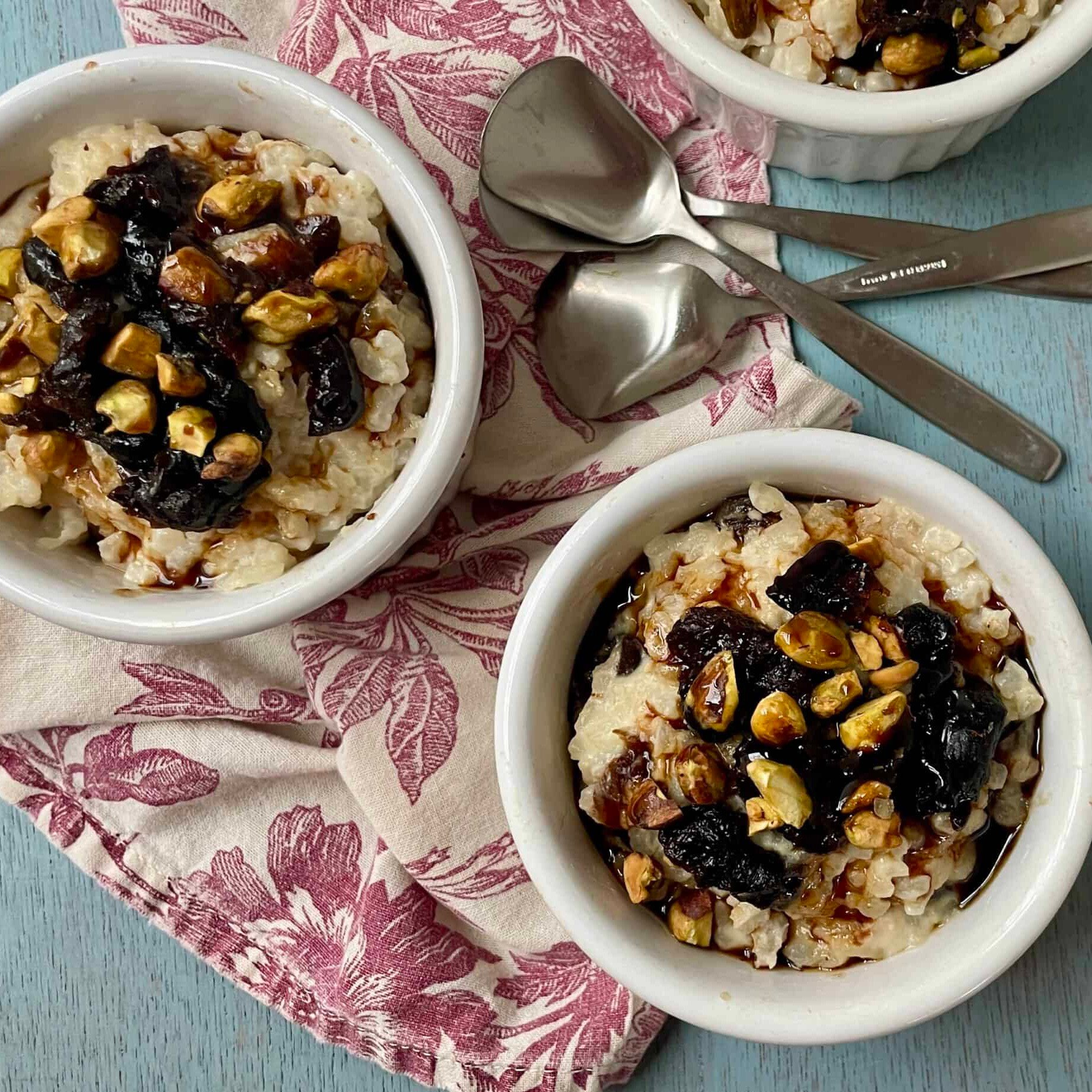 Bowls of Prune-Pomegranate Risotto Pudding with spoons