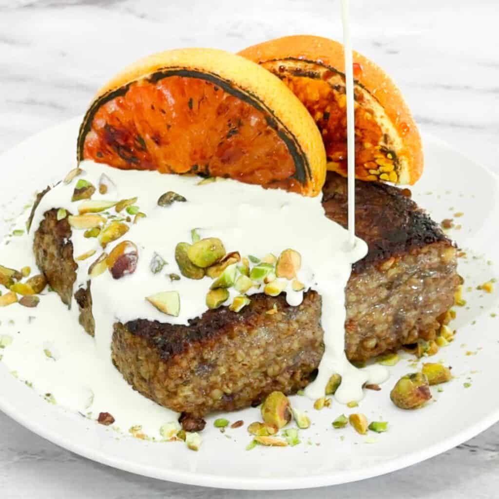 Pan Seared Oatmeal Cakes from Jerry James Stone on a plate topped with citrus and cream