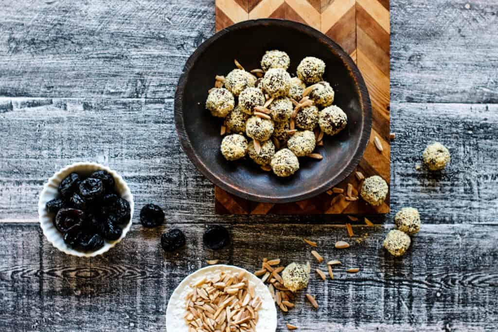 prune truffles rolled in ground almonds in a black bowl