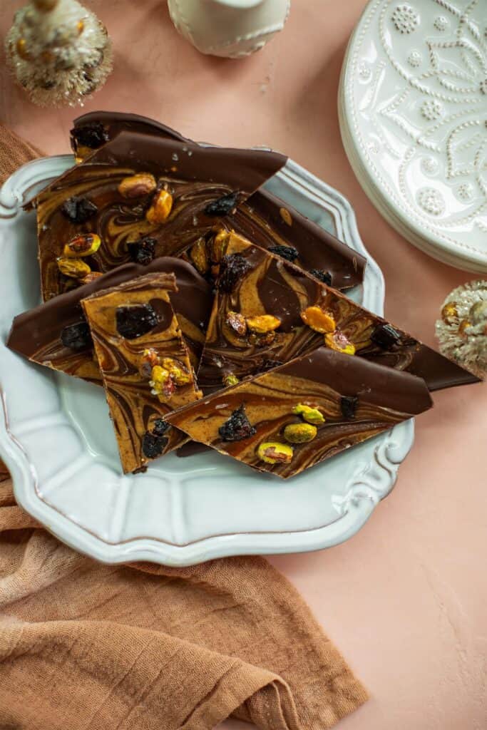 chocolate bark on a light blue plate topped with pistachios