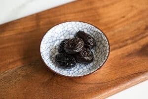 prunes in a crackled blue and white bowl on a board