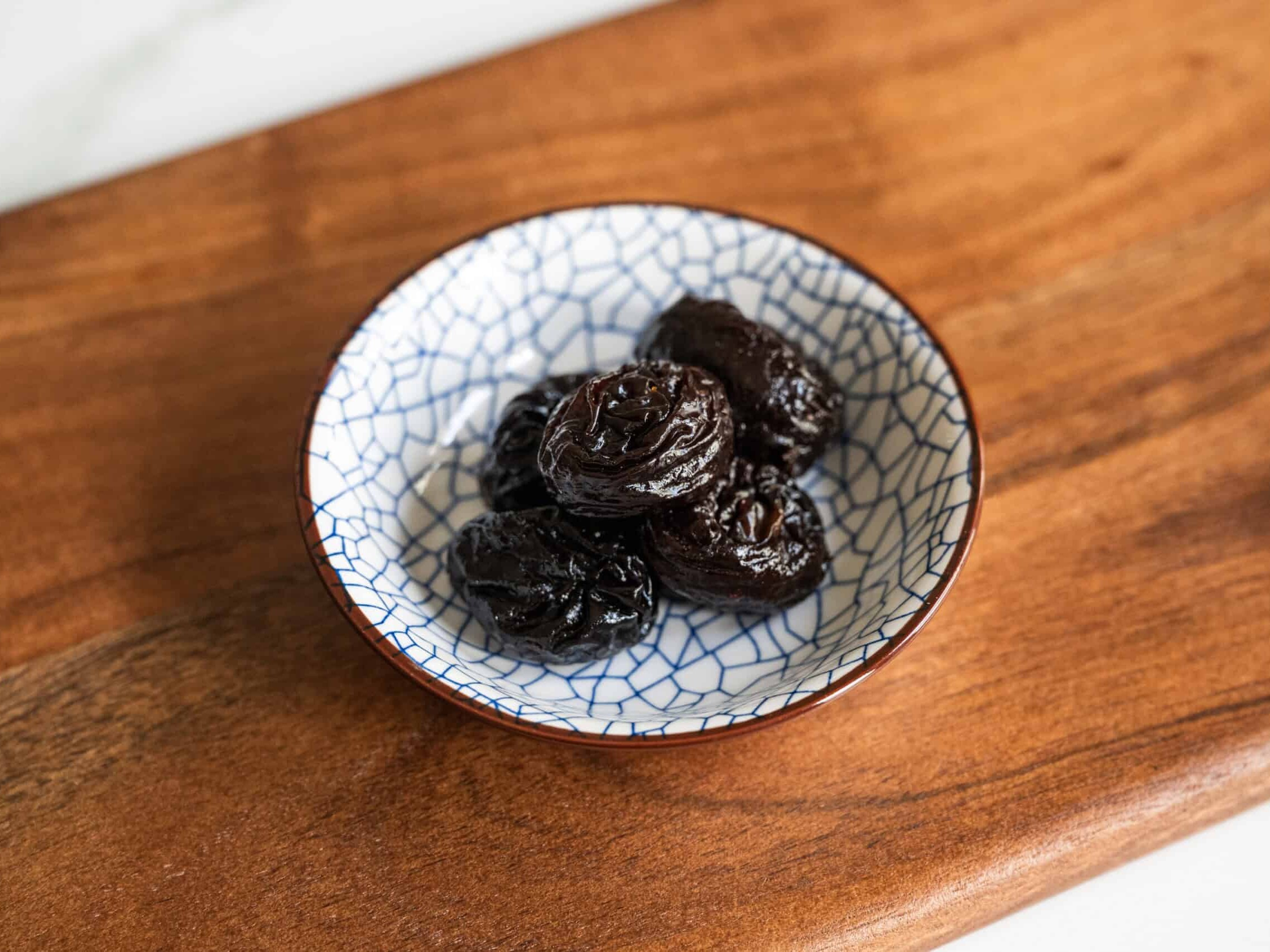 prunes in a crackled blue and white bowl on a board