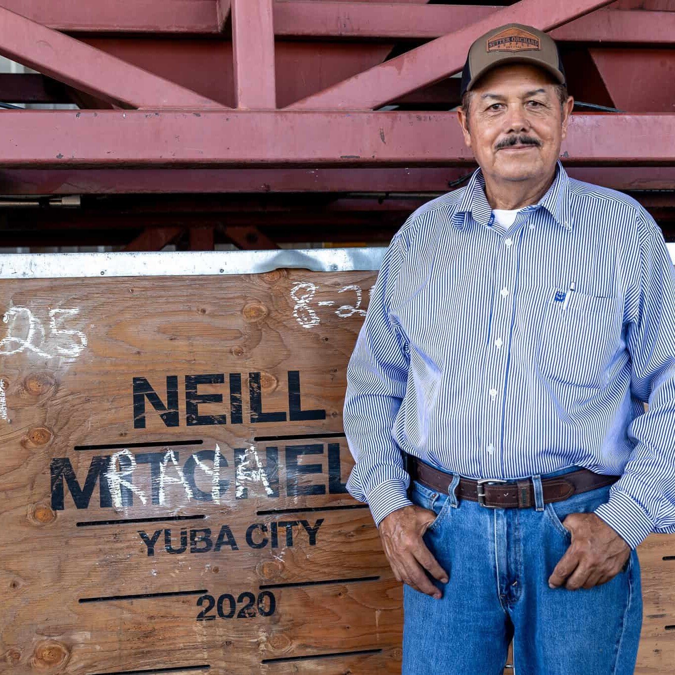 Jose Raya standing next to a crate bearing his name