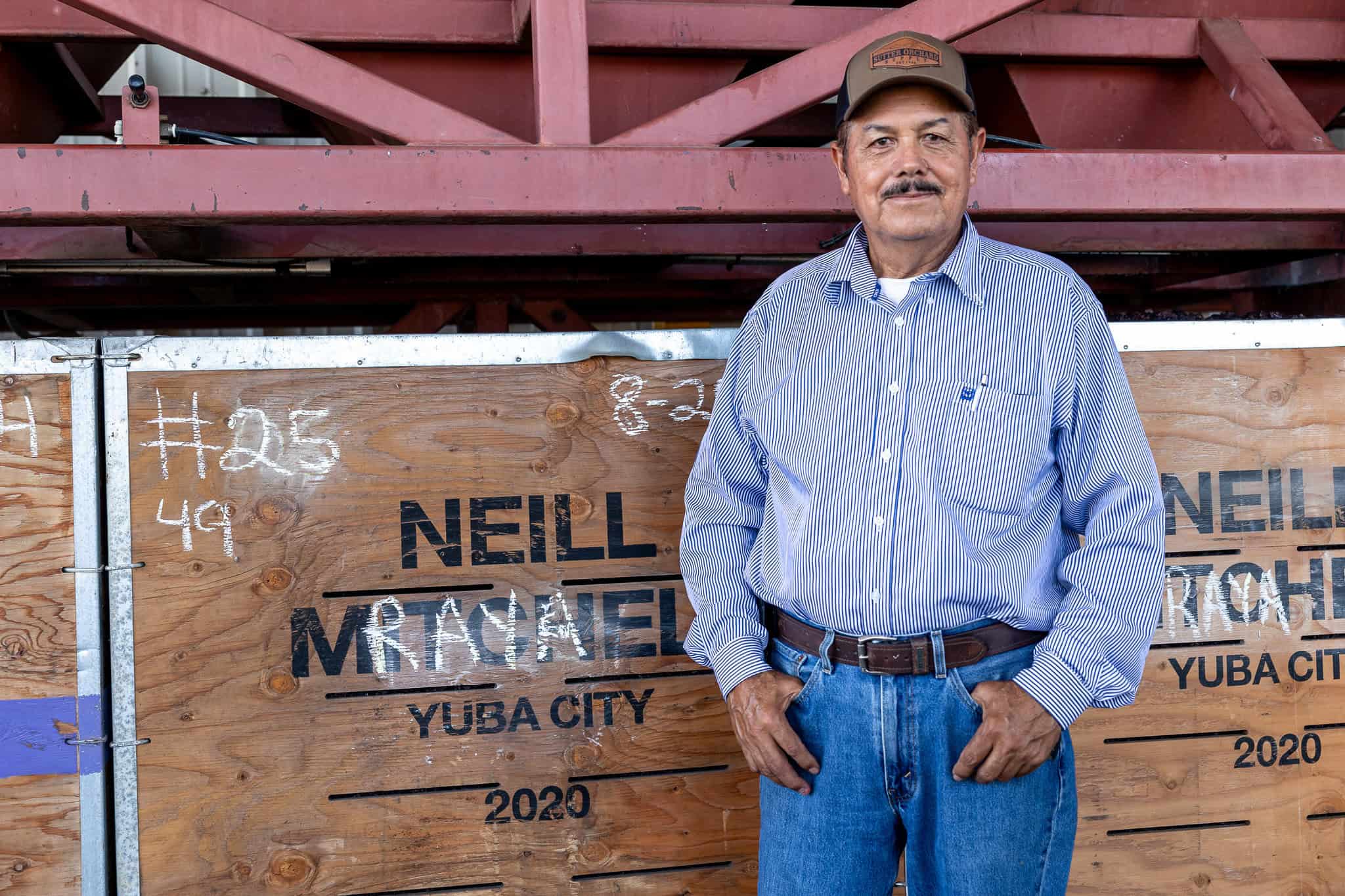 Jose Raya standing next to a crate bearing his name