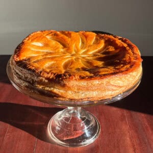 overhead shot of a galette des rois on a cake stand