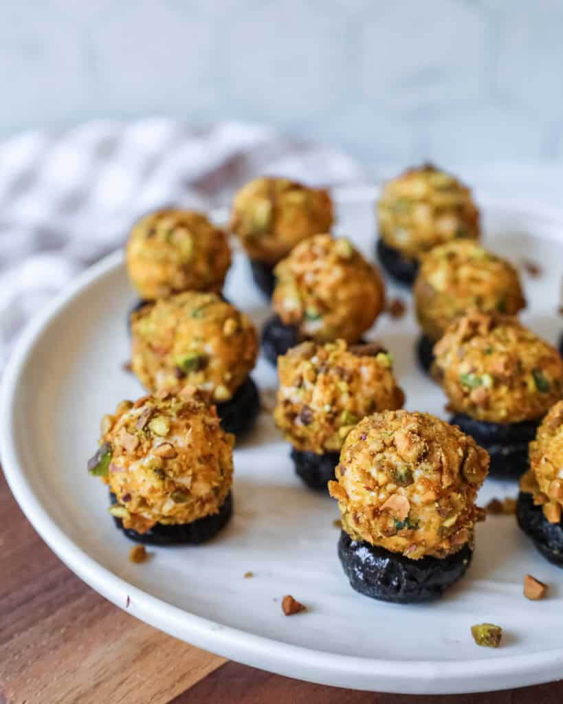 cheeseball stuffed prunes arranged on a platter