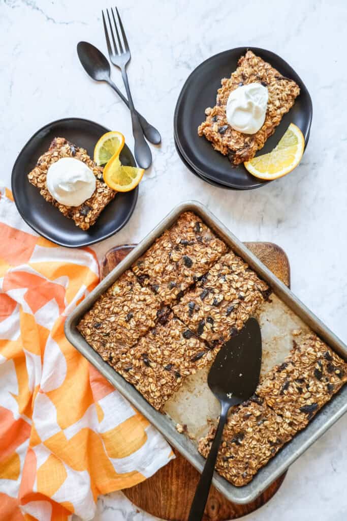 sheet pan baked oatmeal in a silver quarter sheet pan with some slices on black plates