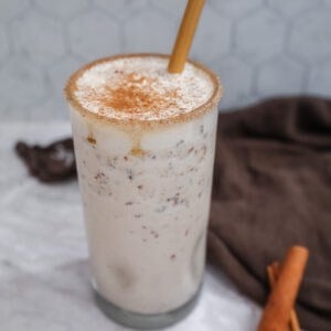 snickerdoodle smoothie in a glass with a bamboo straw