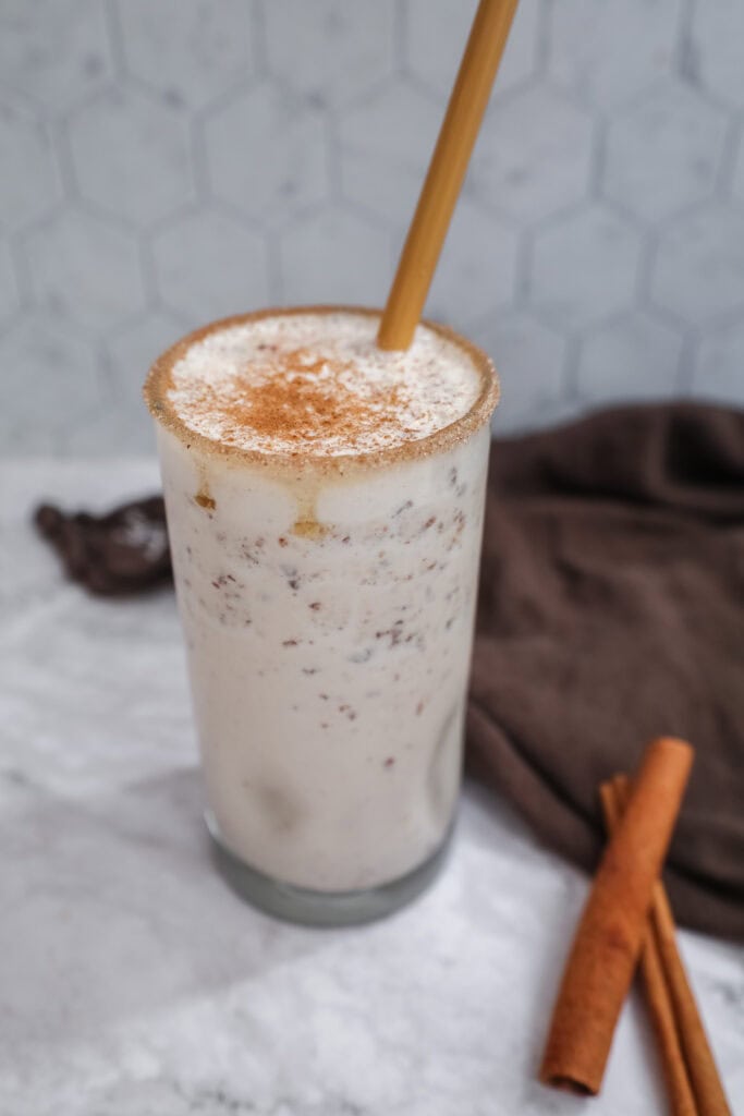 snickerdoodle smoothie in a glass with a bamboo straw