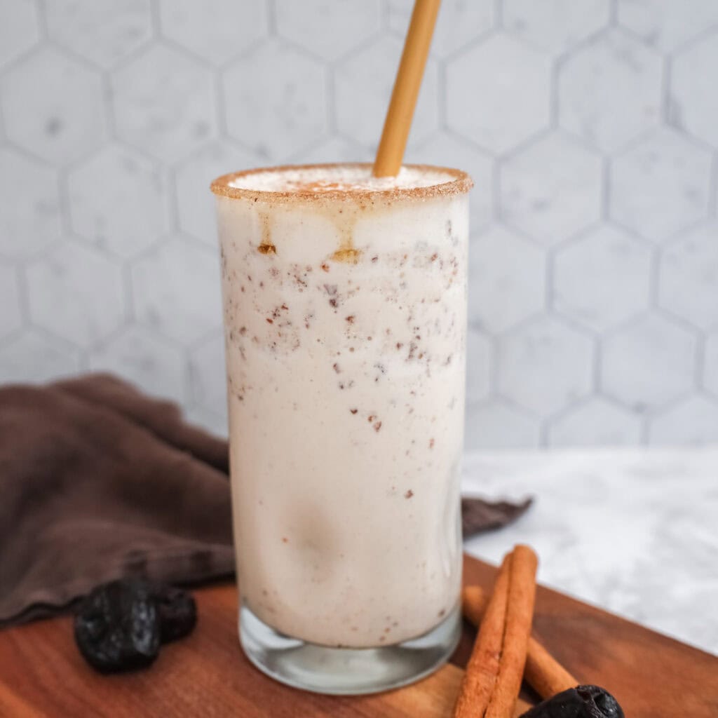 snickerdoodle smoothie in a glass with a bamboo straw