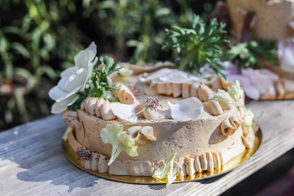 prune coconut cake frosted with swiss buttercream and topped with fresh flowers