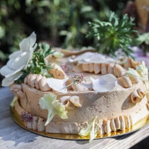 prune coconut cake frosted with swiss buttercream and topped with fresh flowers