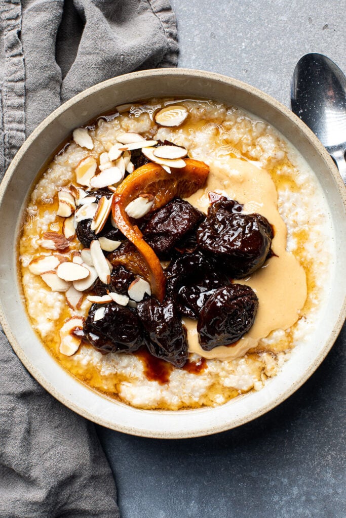 oatmeal topped with stewed prunes and sliced almonds