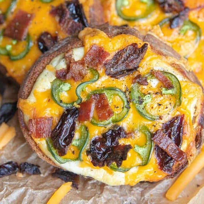 A close up of one pieces of Sweet and Spicy Cheese Toast with all the fixin's from sliced prunes and jalapenos to crispy bacon.