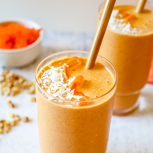 carrot cake reset smoothie in a clear glass topped with coconut