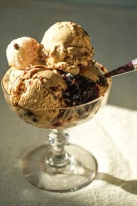 dulce de leche no churn ice cream in a dish toppedno churn ice cream topped with with Beijinho Fudge Balls in a glass ice cream dish