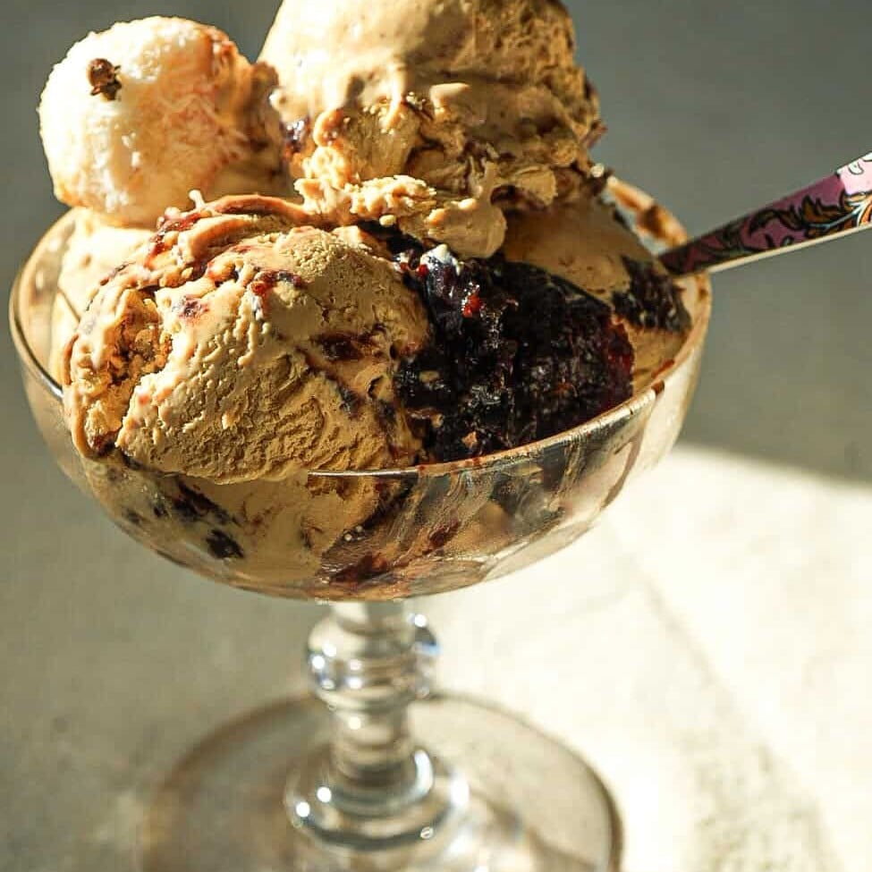dulce de leche no churn ice cream in a dish toppedno churn ice cream topped with with Beijinho Fudge Balls in a glass ice cream dish
