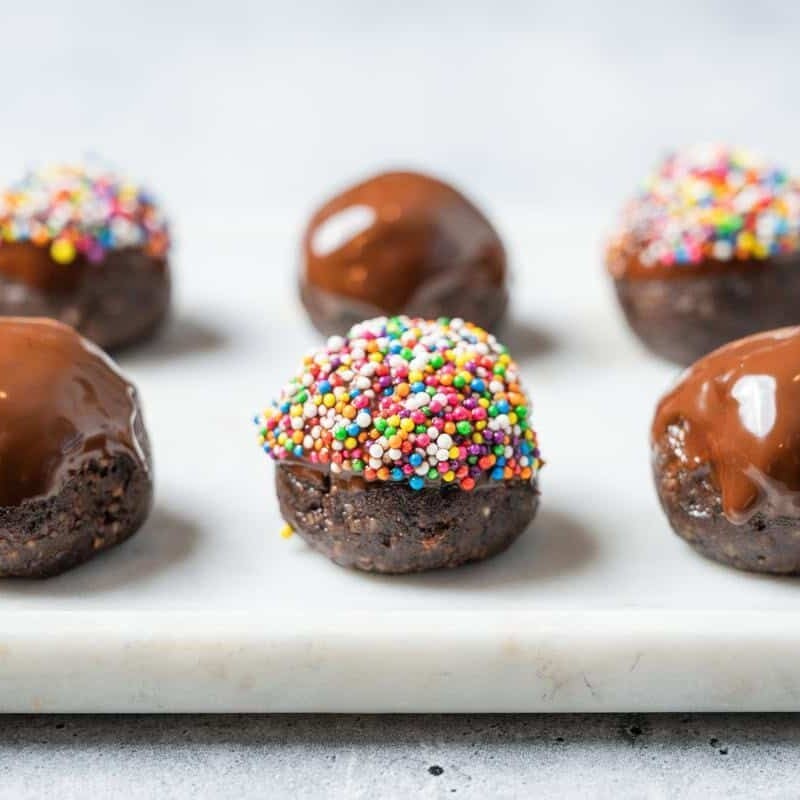 chocolate prune balls with sprinkles on a white platter