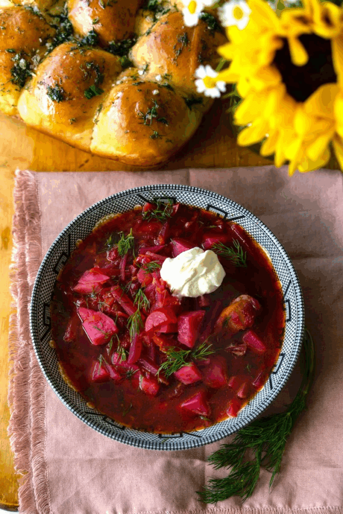 borshch in a white bowl garnished with sour cream