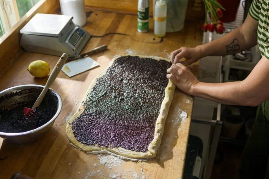 woman rolling dough into a log shape