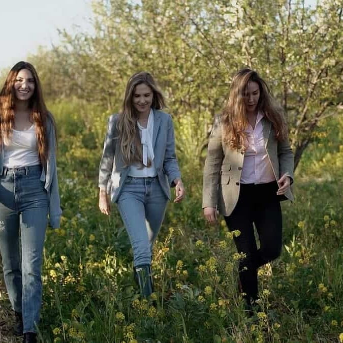 taylor sisters walking through a prune orchard
