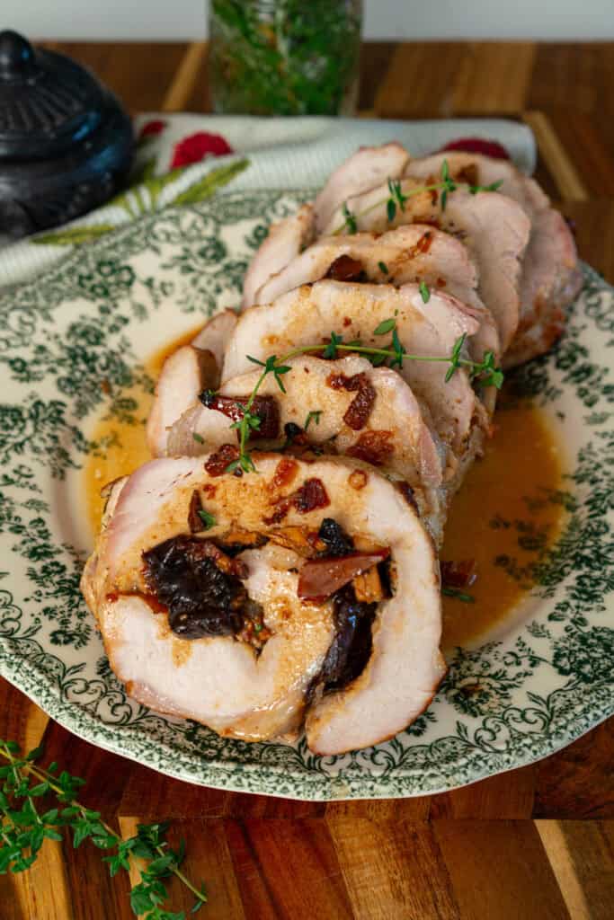 sliced pork roulade on a green and white plate