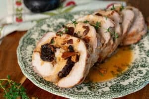 sliced pork roulade on a green and white plate
