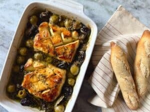 halloumi marbella in a square baking dish with a side of bread