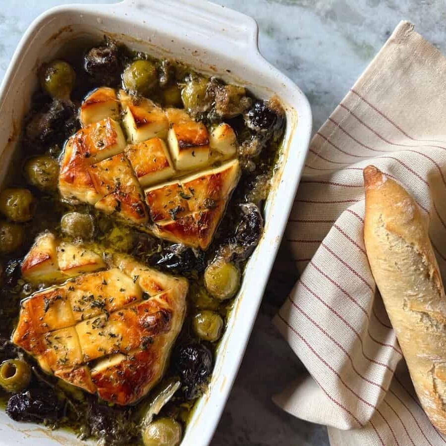 halloumi marbella in a square baking dish with a side of bread