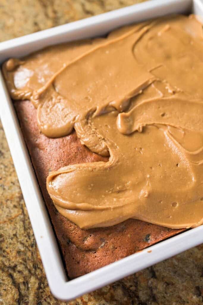 frosting spread over the top of the prune spice cake