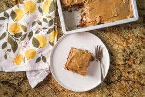 overhead shot of a square of prune spice cake on a white plate