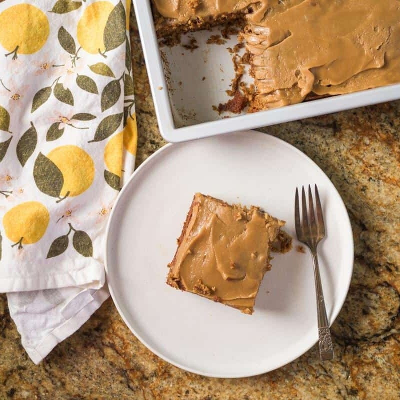 overhead shot of a square of prune spice cake on a white plate