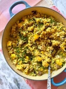 pork and orzo pilaf in a blue cast iron pan