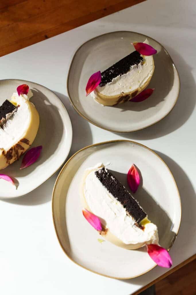 slices of goose breast cake on white plates