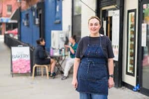 woman standing on sidewalk outside bakery in Brooklyn
