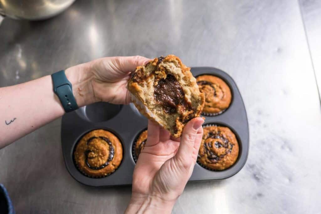 woman tearing open banana muffin