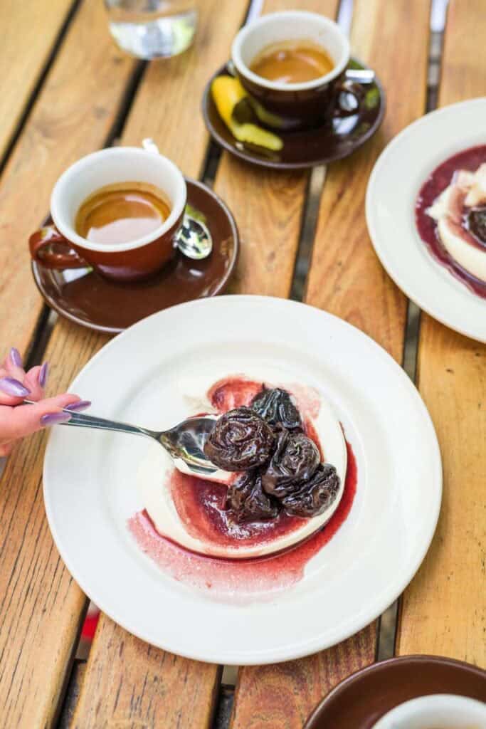 woman scooping red wine prunes onto a spoon