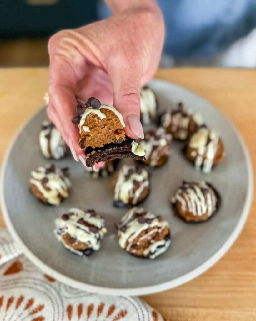 woman holding a bitten cookie dough bite